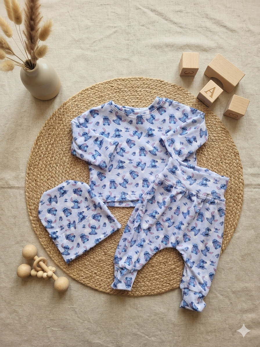 Baby outfit with floral pattern on a woven mat with wooden blocks and a vase in the background.
